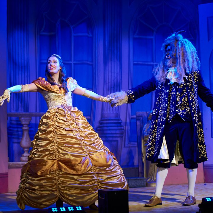 Two actors in an elaborately designed stage set.