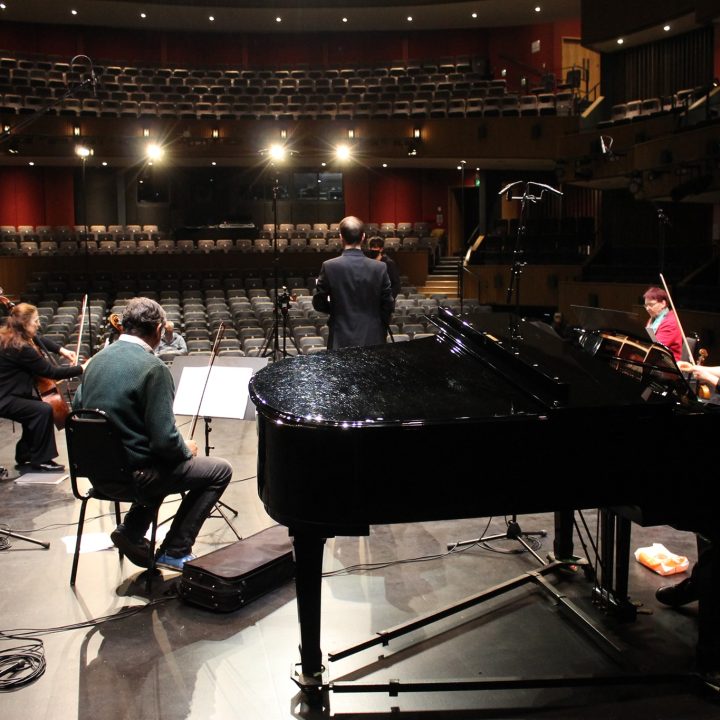 A group of musicians, including a pianist, violinist, and cellist.