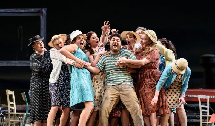 A group of people on Grove Theatre stage, many wearing hats and vintage clothing.