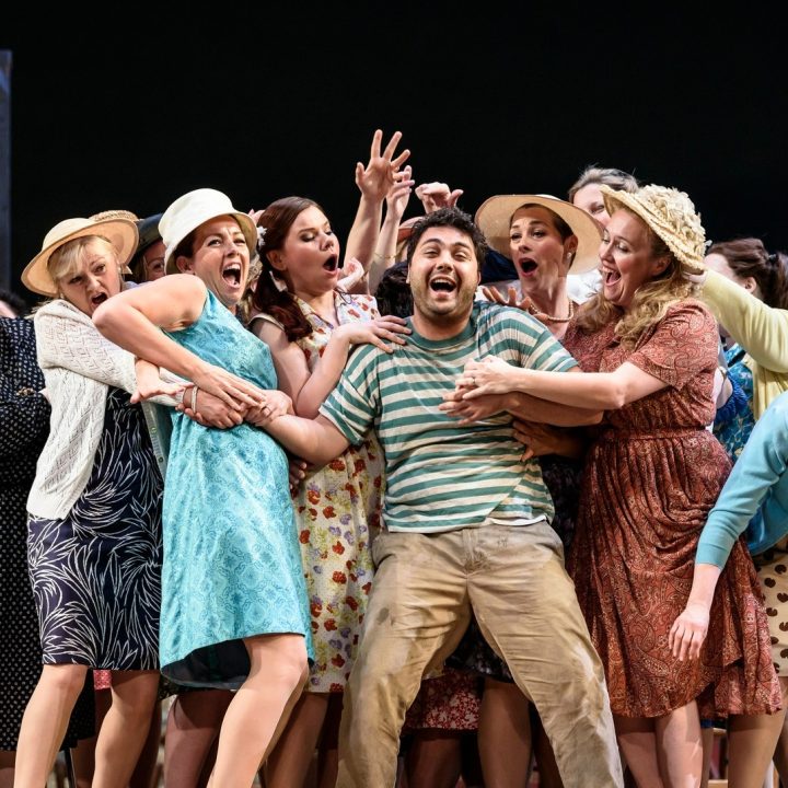 A group of people on Grove Theatre stage, many wearing hats and vintage clothing.