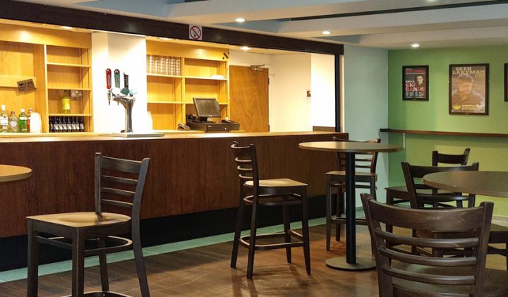 Empty bar with wooden high tables, taps, and posters-perfect for a pre-theatre visit.