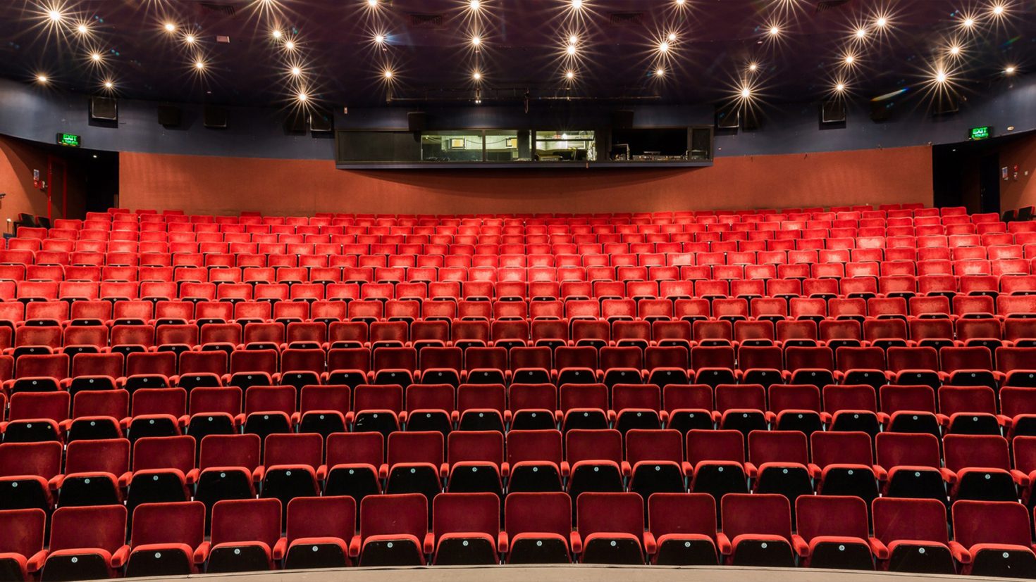 Discover the dimly lit Gordon Craig Theatre with its iconic red seats.