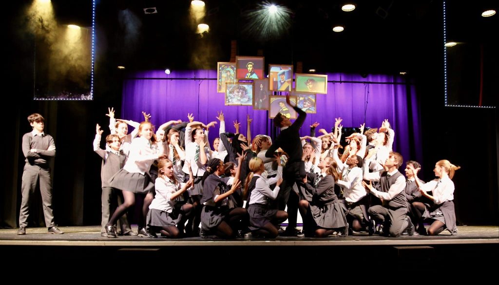 A Brilliant Theatre Arts performance with a large ensemble cast on stage.